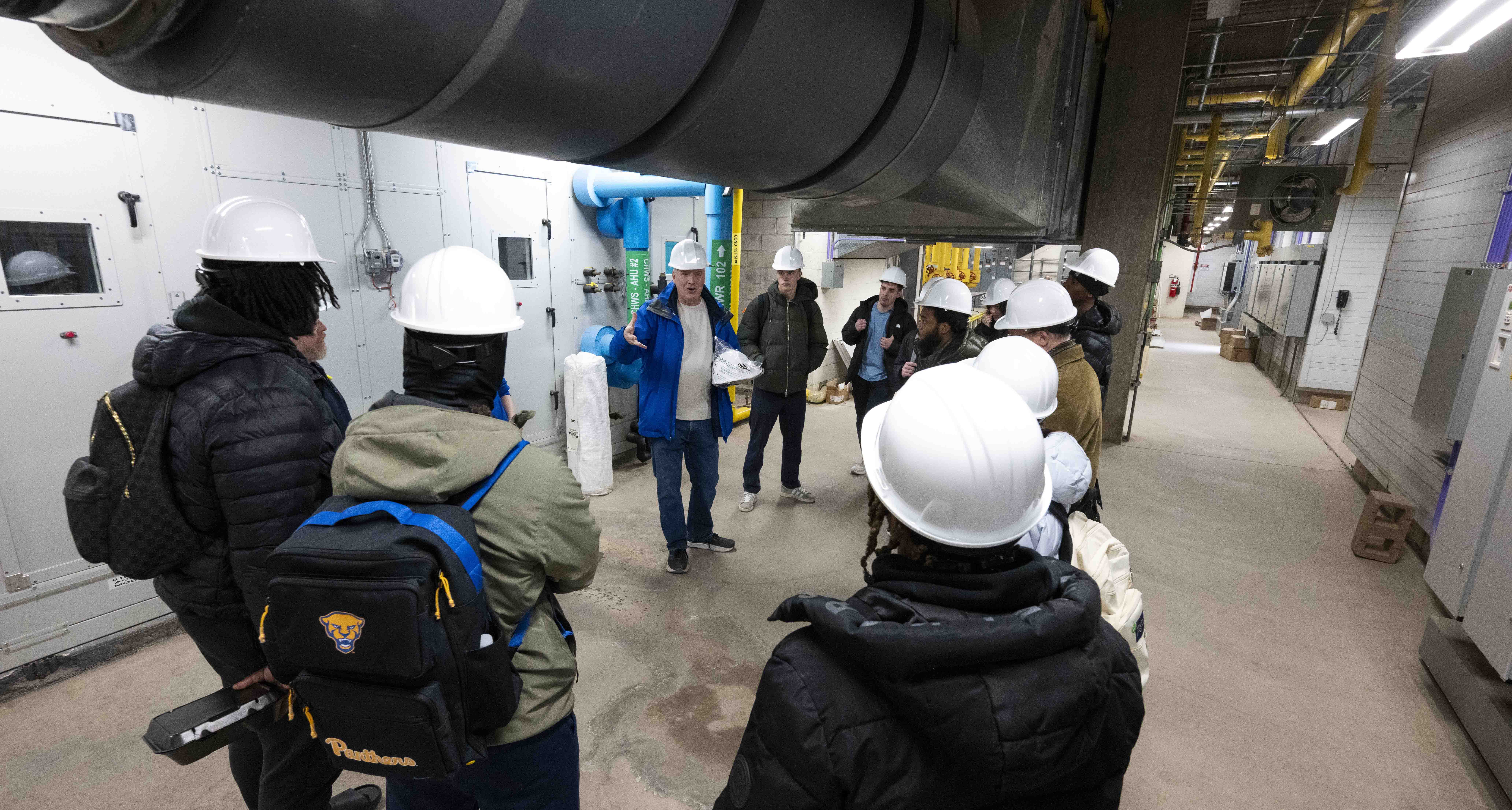 Gallagher's “PHYS 0088 Physics of Energy” class involves hands-on learning, like the tour of the Posvar Hall chiller plant to demonstrate the complexities of regulating and distributing steam and water to heat and cool buildings. (Tom Altany | University of Pittsburgh) Gallagher and students on Posvar tour