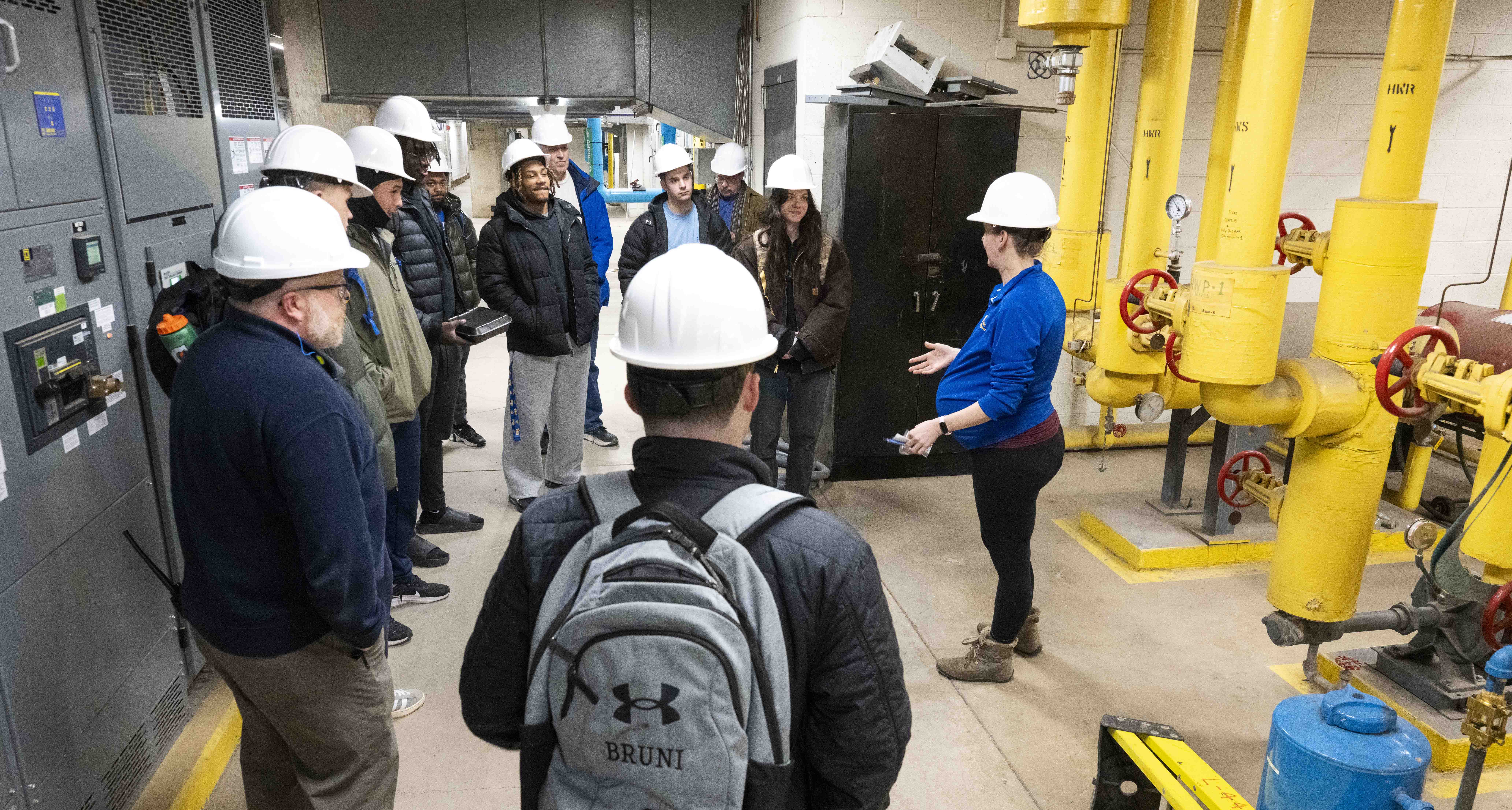 Audra Delo, right, senior manager of mechanical engineering, explains to students the inner workings of Pitt’s thermal management system on a February tour of the Oakland thermal management systems for a physics class taught by former Pitt chancellor Pat Gallagher. (Photos by Tom Altany | University of Pittsburgh)