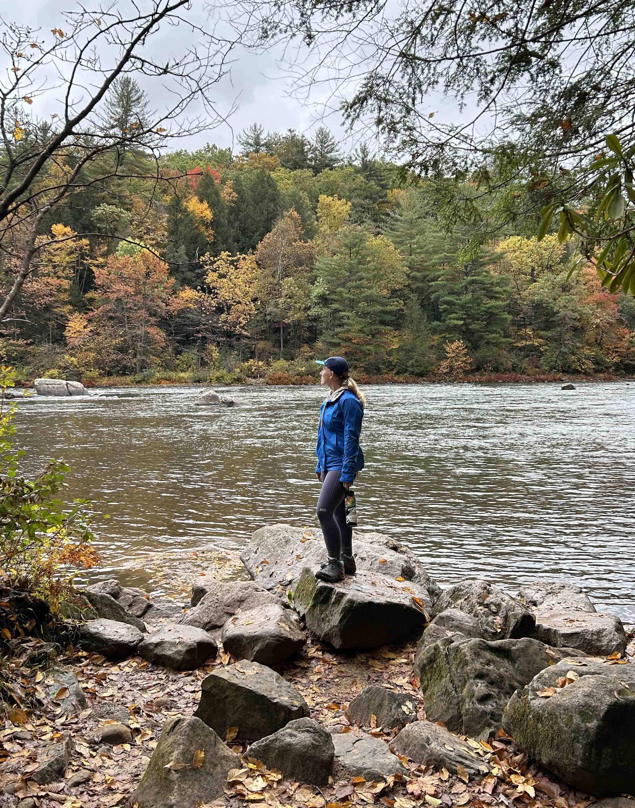 Woman standing on rock near river