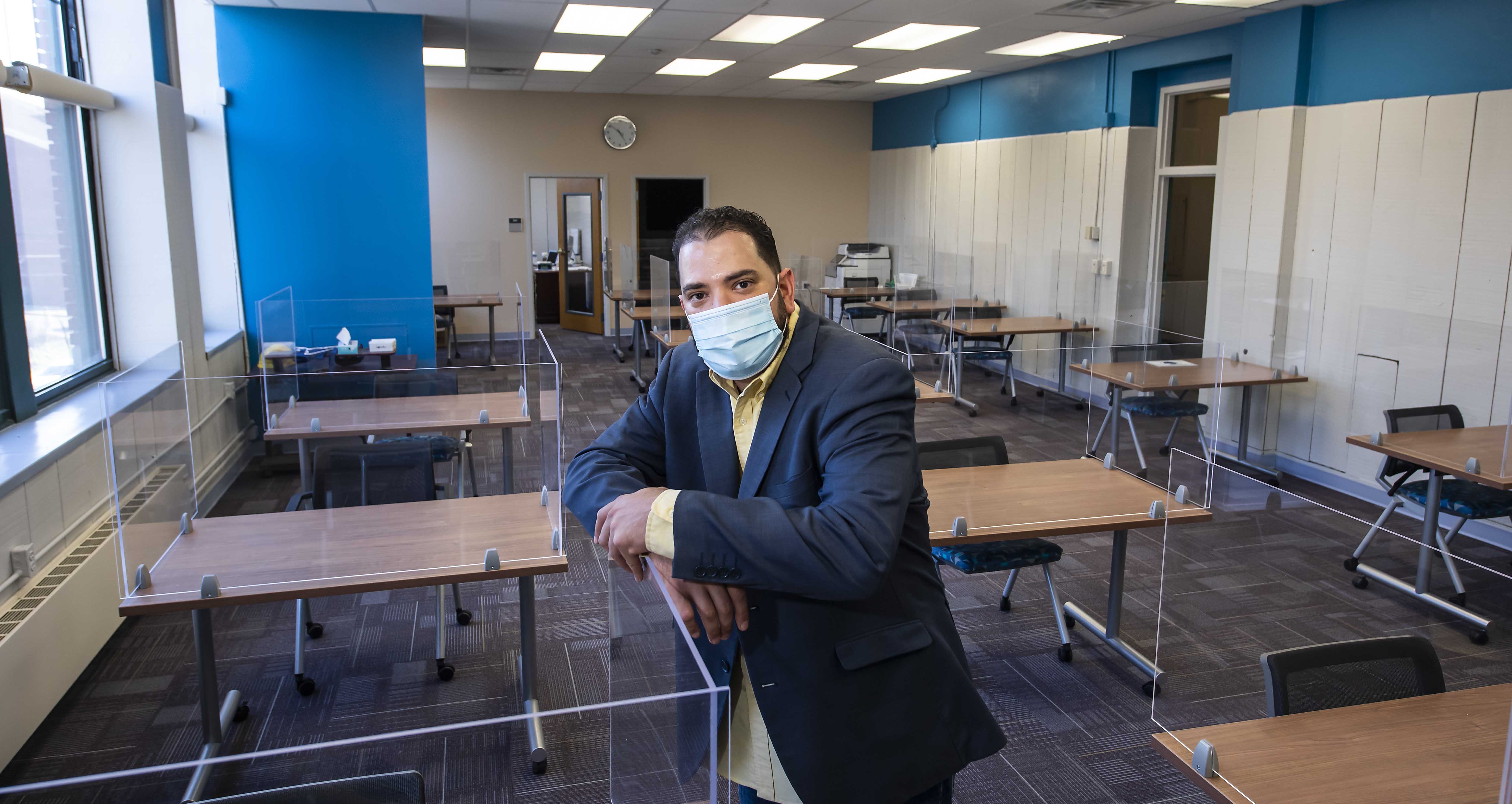man in mask standing in classroom