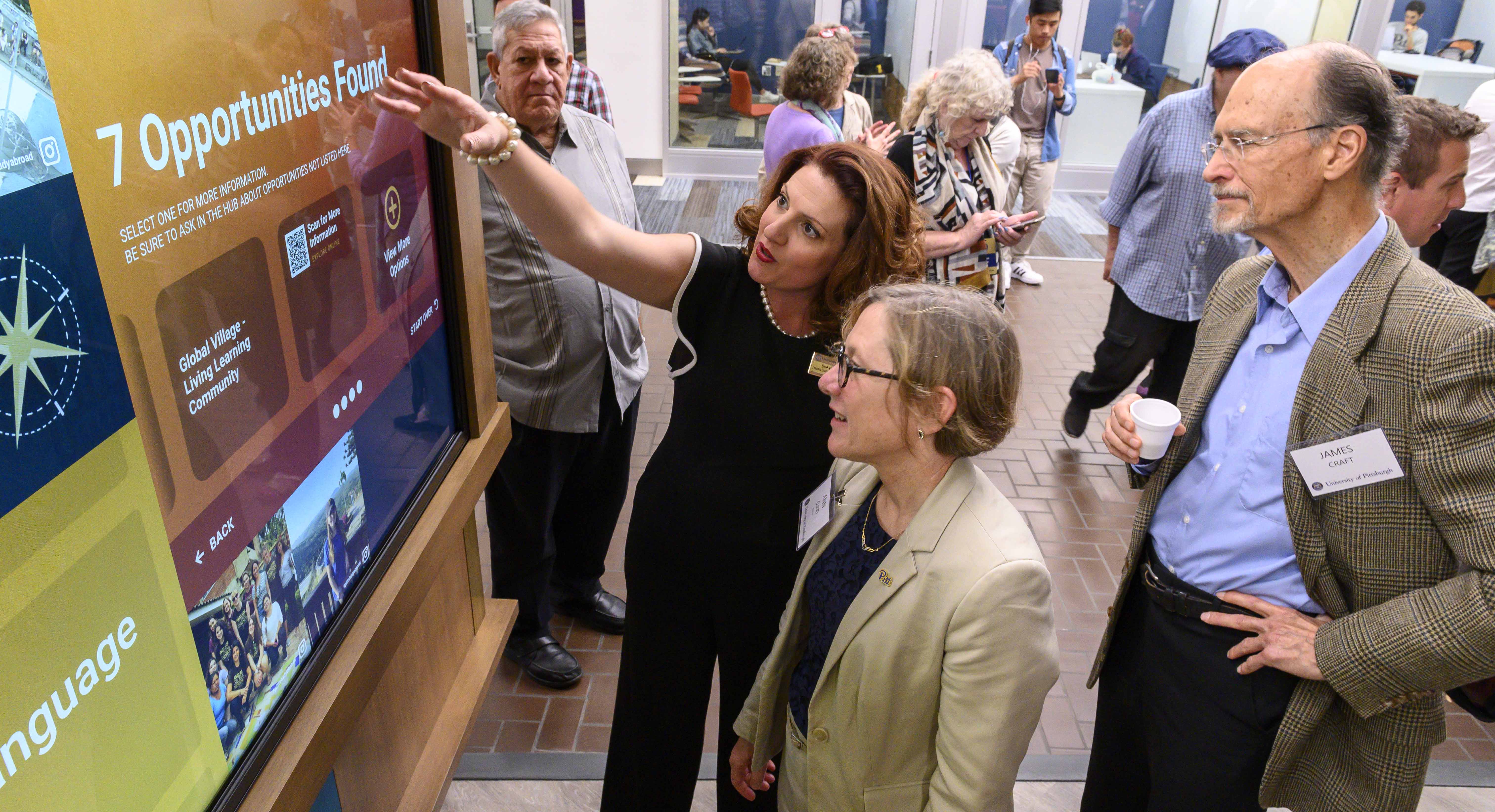 Belkys Torres shows Provost Cudd one of the interactive walls
