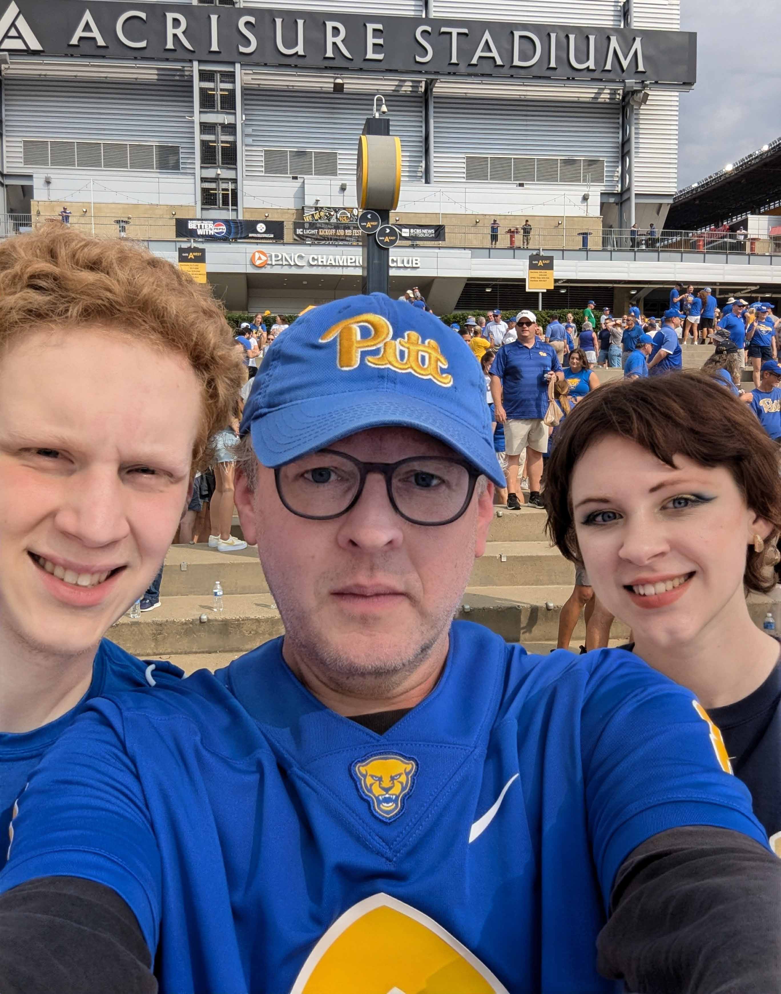 Man with two teens at stadium