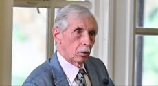 Charles Perfetti speaking in front of windows